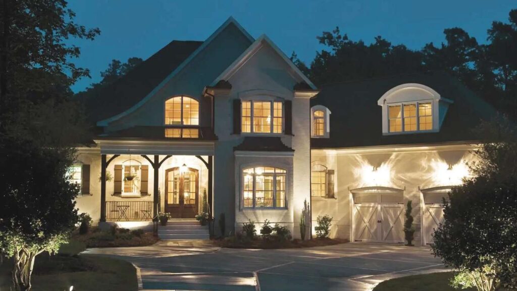 Large home at dusk with efficient exterior and landscape lighting