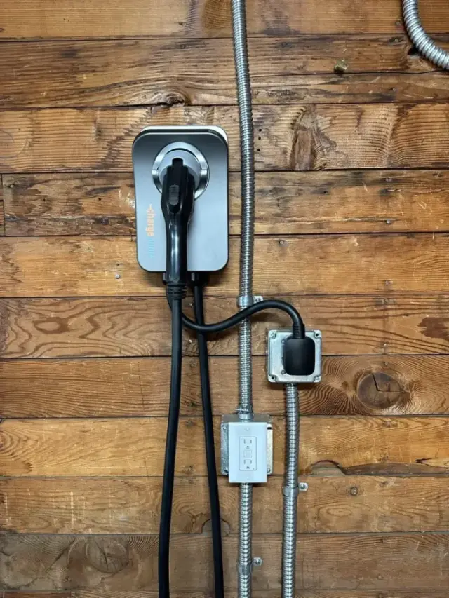 Wall-mounted EV charger installed on a wood-paneled wall